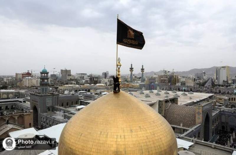 اهتزاز پرچم عزای حسینی بر فراز گنبد حرم ثامن‌الحجج(ع)